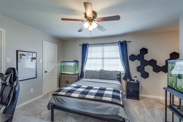 carpeted bedroom featuring ceiling fan and a textured ceiling