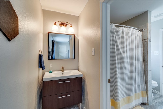 bathroom featuring visible vents, a textured wall, toilet, vanity, and a shower with curtain