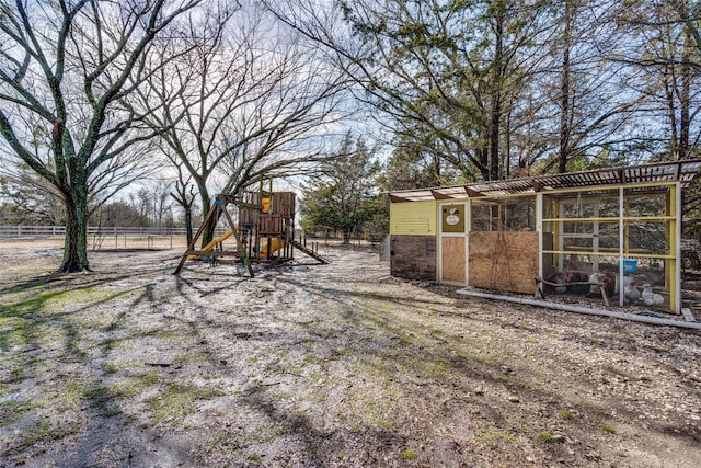 view of playground with an outdoor structure and fence