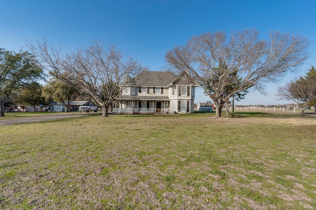 exterior space with a porch, fence, and a front lawn