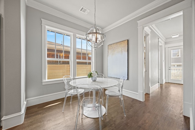 dining space featuring an inviting chandelier, dark wood-type flooring, and ornamental molding