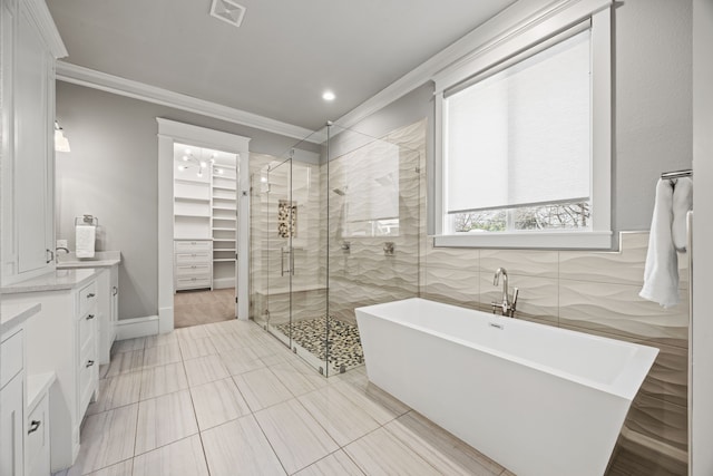 bathroom featuring crown molding, vanity, and separate shower and tub