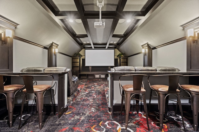 carpeted home theater with coffered ceiling, beamed ceiling, and bar