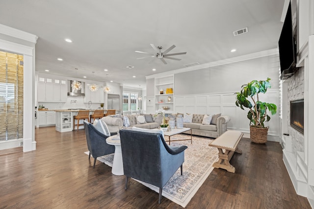 living room with ceiling fan, ornamental molding, and dark hardwood / wood-style flooring