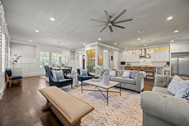 living room with crown molding, ceiling fan, and dark hardwood / wood-style flooring