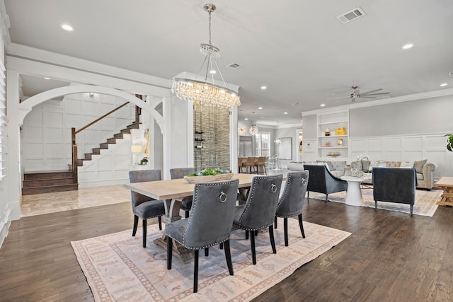 dining room with ceiling fan with notable chandelier, ornamental molding, and dark hardwood / wood-style floors