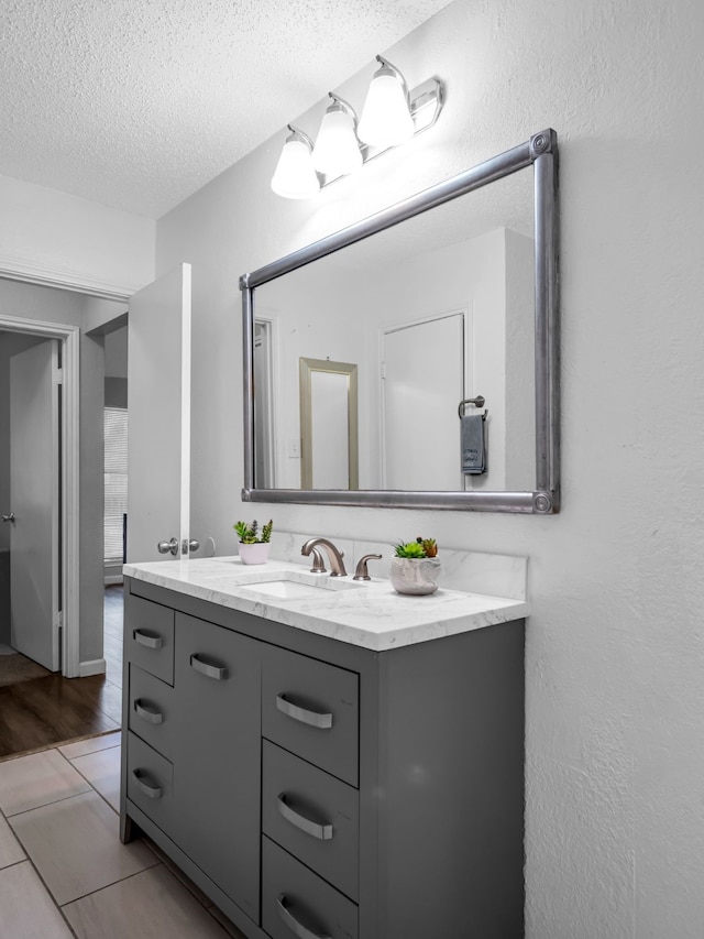 bathroom with vanity, hardwood / wood-style floors, and a textured ceiling