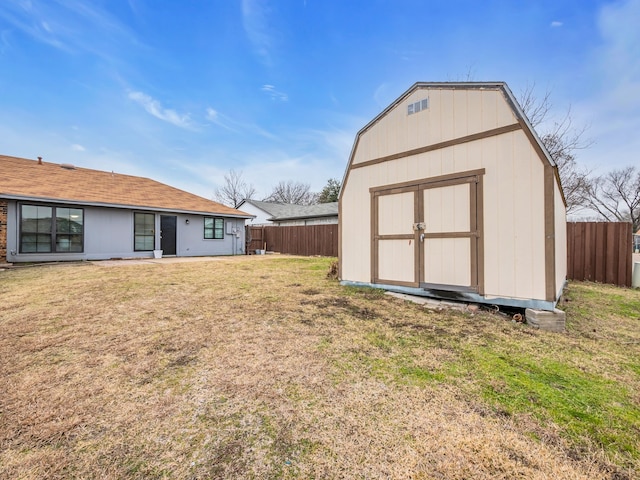 rear view of property with a storage shed and a lawn