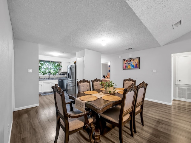 dining room featuring dark hardwood / wood-style flooring, sink, and a textured ceiling