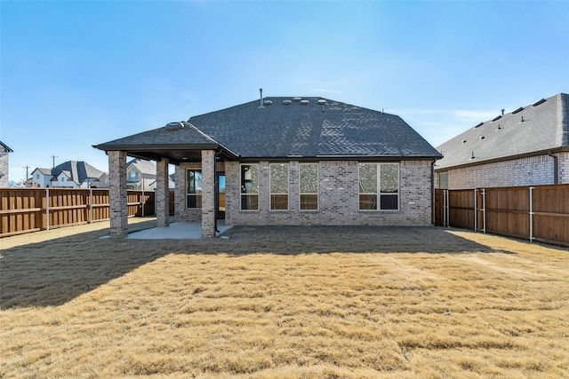 rear view of property with a yard and a patio