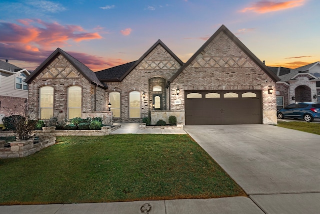 view of front of house with a garage and a yard