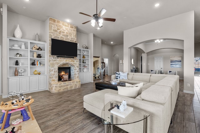 living room with dark hardwood / wood-style flooring, a fireplace, and ceiling fan