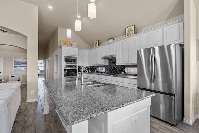 kitchen with sink, stainless steel appliances, tasteful backsplash, white cabinets, and dark stone counters