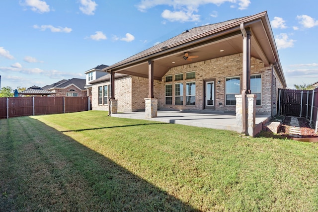 rear view of house with a yard, a patio area, and ceiling fan