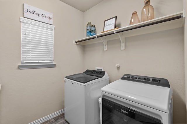 clothes washing area with wood-type flooring and independent washer and dryer