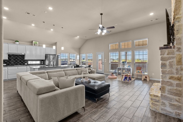 living room featuring a towering ceiling and ceiling fan