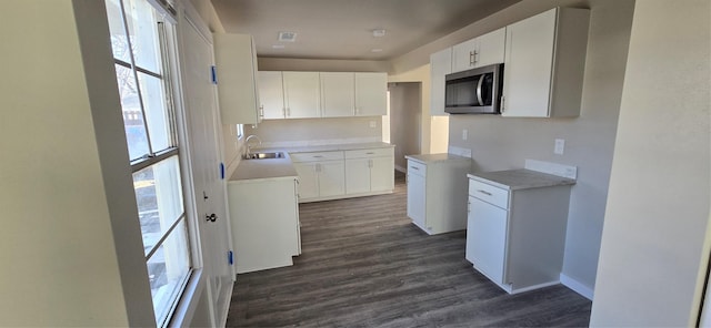 kitchen with dark hardwood / wood-style floors, sink, and white cabinets