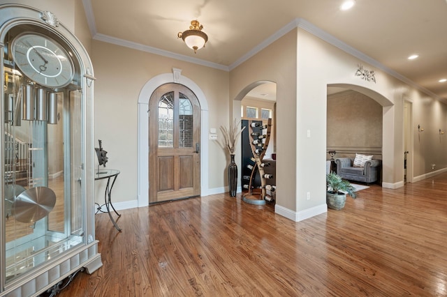 foyer entrance with hardwood / wood-style flooring and ornamental molding