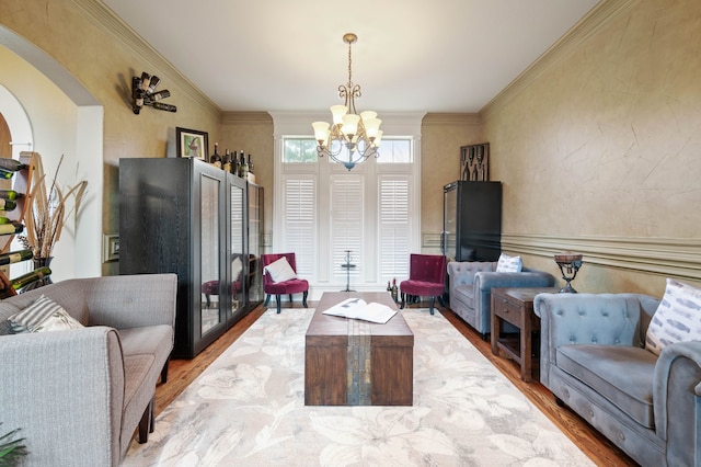 living room featuring ornamental molding, a chandelier, and wood-type flooring