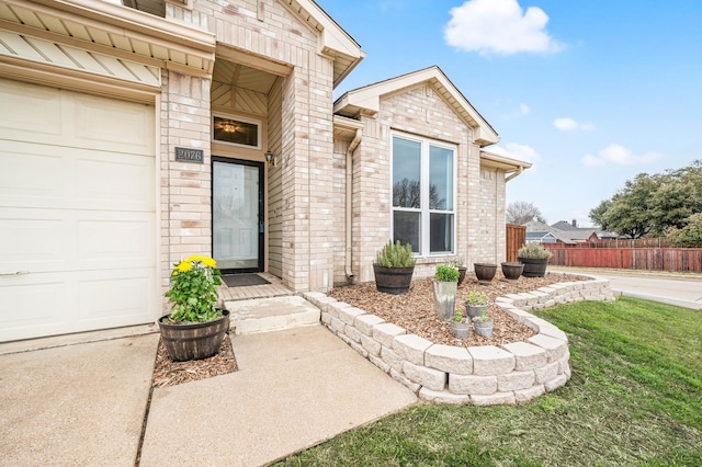 view of exterior entry with a garage and a yard