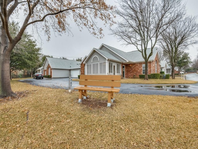 view of front facade featuring a sunroom, a front lawn, and a garage