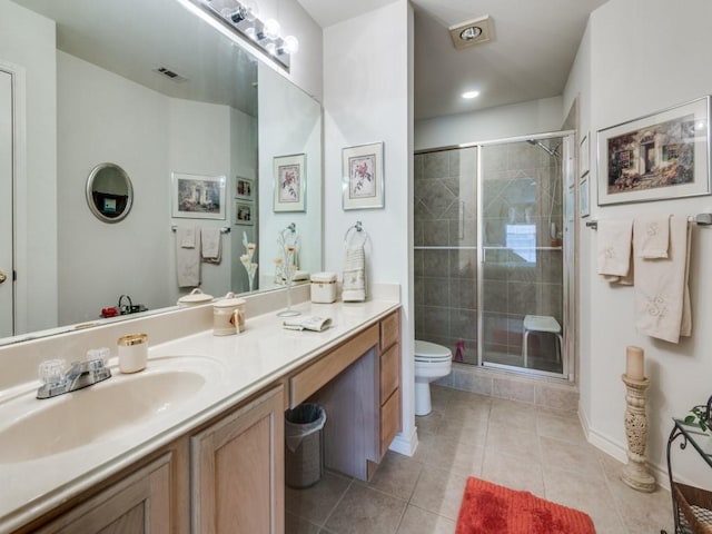 bathroom featuring vanity, tile patterned flooring, a shower with door, and toilet