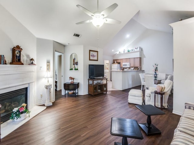 living room with ceiling fan, dark hardwood / wood-style flooring, and vaulted ceiling