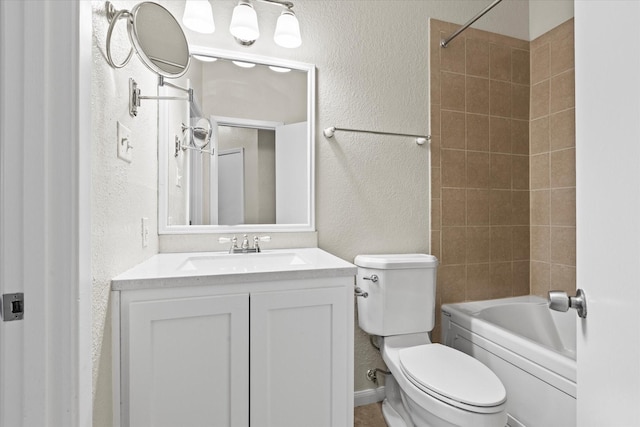 full bathroom featuring tiled shower / bath, vanity, and toilet