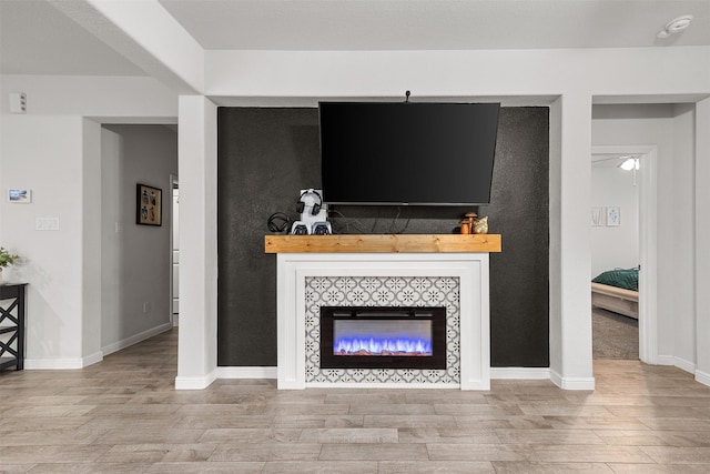 living room featuring a tile fireplace and light hardwood / wood-style flooring