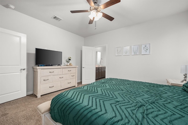 carpeted bedroom featuring ceiling fan and ensuite bath