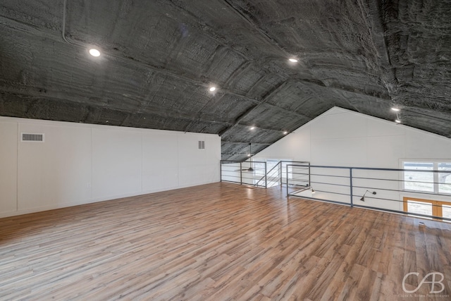 additional living space featuring hardwood / wood-style flooring and vaulted ceiling