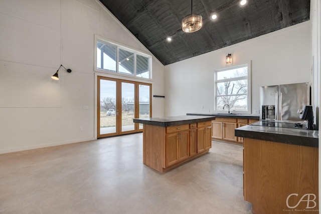 kitchen featuring stainless steel fridge with ice dispenser, a wealth of natural light, high vaulted ceiling, and a kitchen island