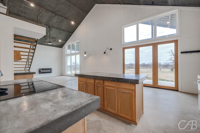 kitchen with black electric cooktop and high vaulted ceiling