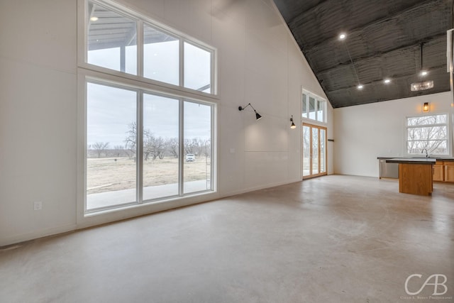 unfurnished living room featuring sink and high vaulted ceiling