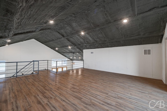 unfurnished room featuring lofted ceiling and wood-type flooring