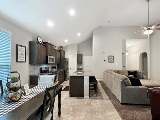 kitchen featuring appliances with stainless steel finishes, sink, a kitchen bar, a kitchen island with sink, and ceiling fan