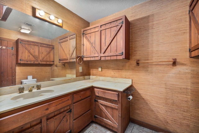 bathroom featuring vanity, toilet, tile patterned flooring, and a textured ceiling