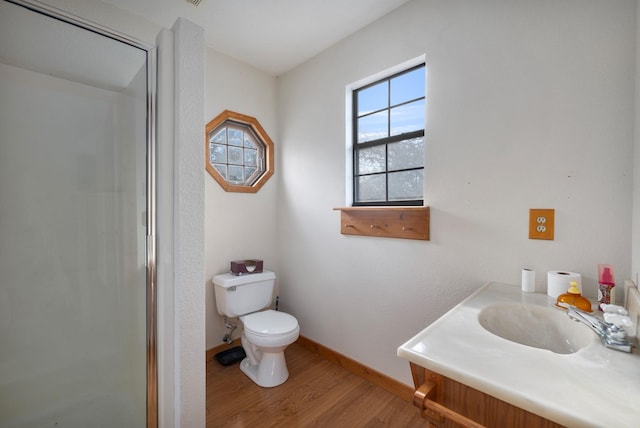 bathroom with hardwood / wood-style flooring, vanity, walk in shower, and toilet