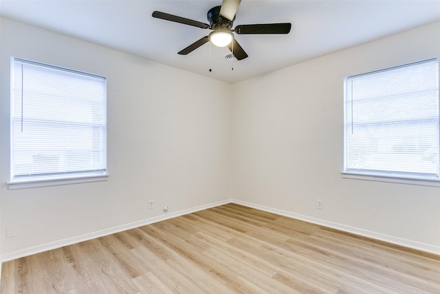 unfurnished room with a wealth of natural light, ceiling fan, and light hardwood / wood-style flooring