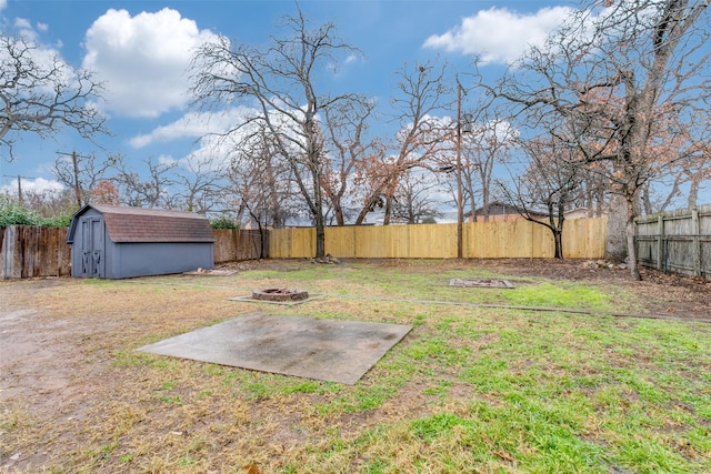 view of yard with a shed, a fire pit, and a patio