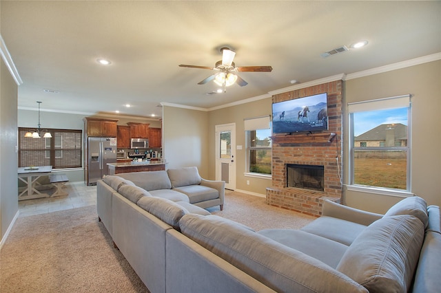 carpeted living room with a brick fireplace, crown molding, a wealth of natural light, and ceiling fan with notable chandelier