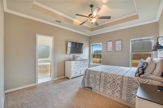 carpeted bedroom with crown molding, ensuite bathroom, and a tray ceiling