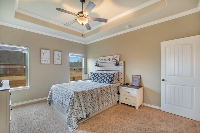 bedroom with crown molding, light colored carpet, and a raised ceiling