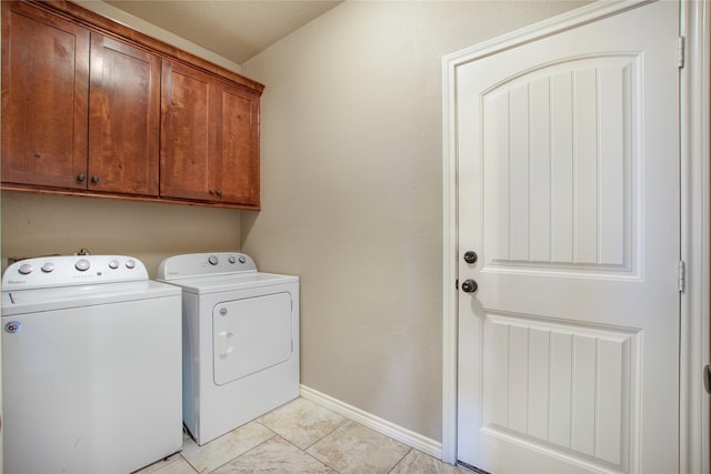 laundry area featuring washer and clothes dryer, cabinets, and light tile patterned flooring