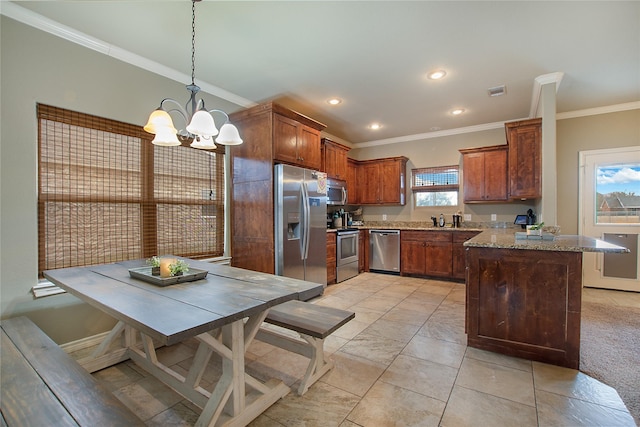 kitchen with pendant lighting, crown molding, appliances with stainless steel finishes, light stone counters, and a chandelier