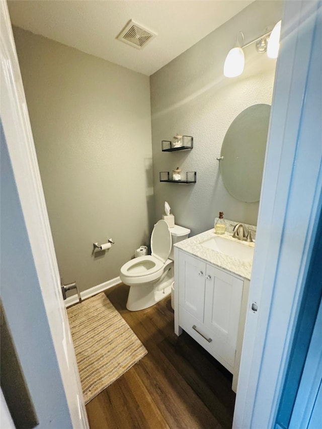 bathroom with hardwood / wood-style flooring, vanity, and toilet