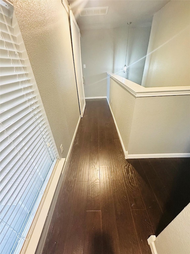 corridor with dark hardwood / wood-style flooring