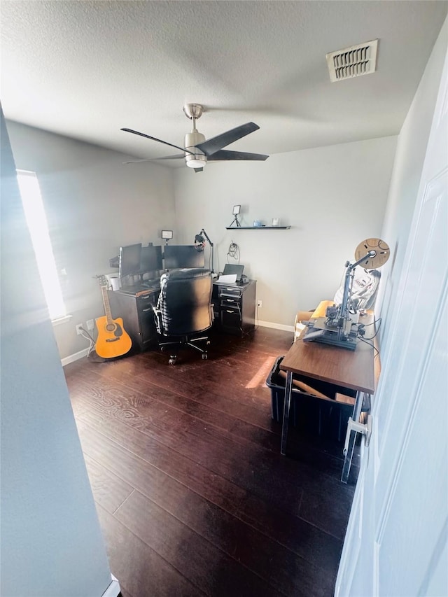 home office with ceiling fan, a textured ceiling, and dark hardwood / wood-style flooring