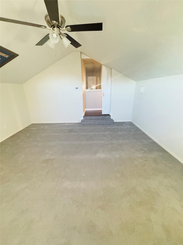 additional living space featuring ceiling fan, lofted ceiling, and dark colored carpet