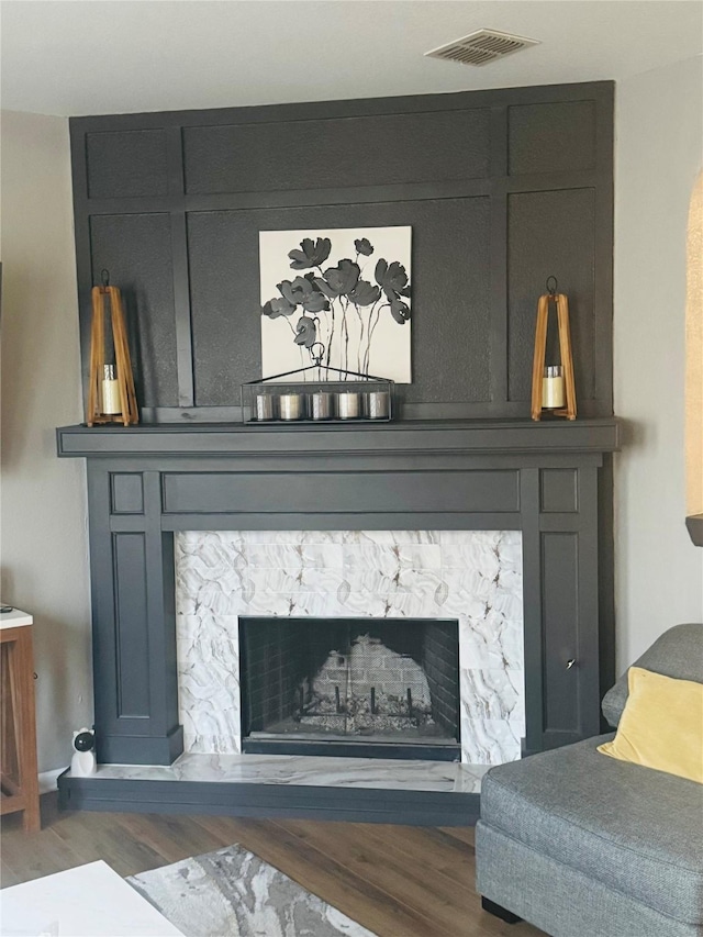 room details featuring a stone fireplace and hardwood / wood-style floors